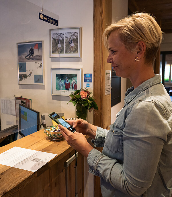 <p>Frau checkt mittels Handy (Gstaad Card) im Hotel ein.</p>