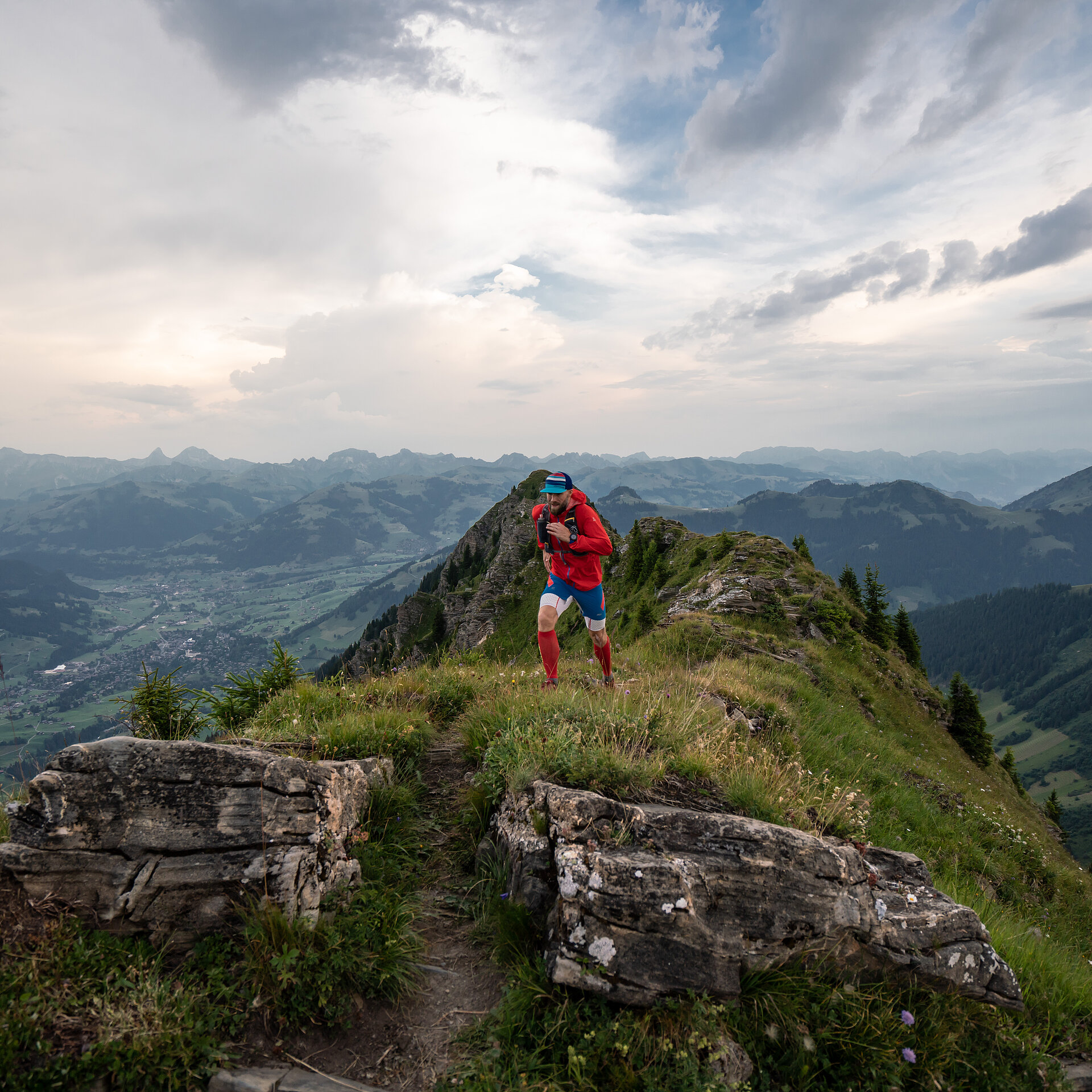 <p>Person in roter Kleidung rennt auf einem Wanderweg den Berg hoch.</p>