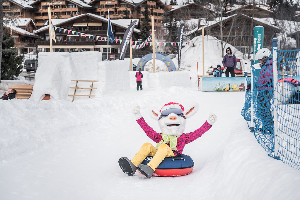 <p>Saani, das Saanenland-Maskottchen rutscht auf einem Ring auf der Piste im Winterspielplatz Saanenmöser.</p>