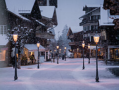 Verschneite Gstaader Promenade mit Lichtern.