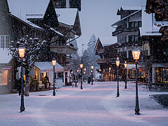 Verschneite Gstaader Promenade mit Lichtern.