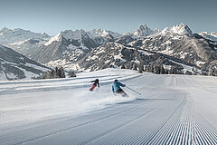 Zwei Skifahrer geniessen die Abfahrt vom Horneggli auf frisch präparierter Piste.