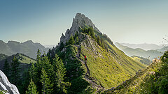 Zwei Wanderer gehen einen spektakulären Grat entlang, einem Gipfel entgegen