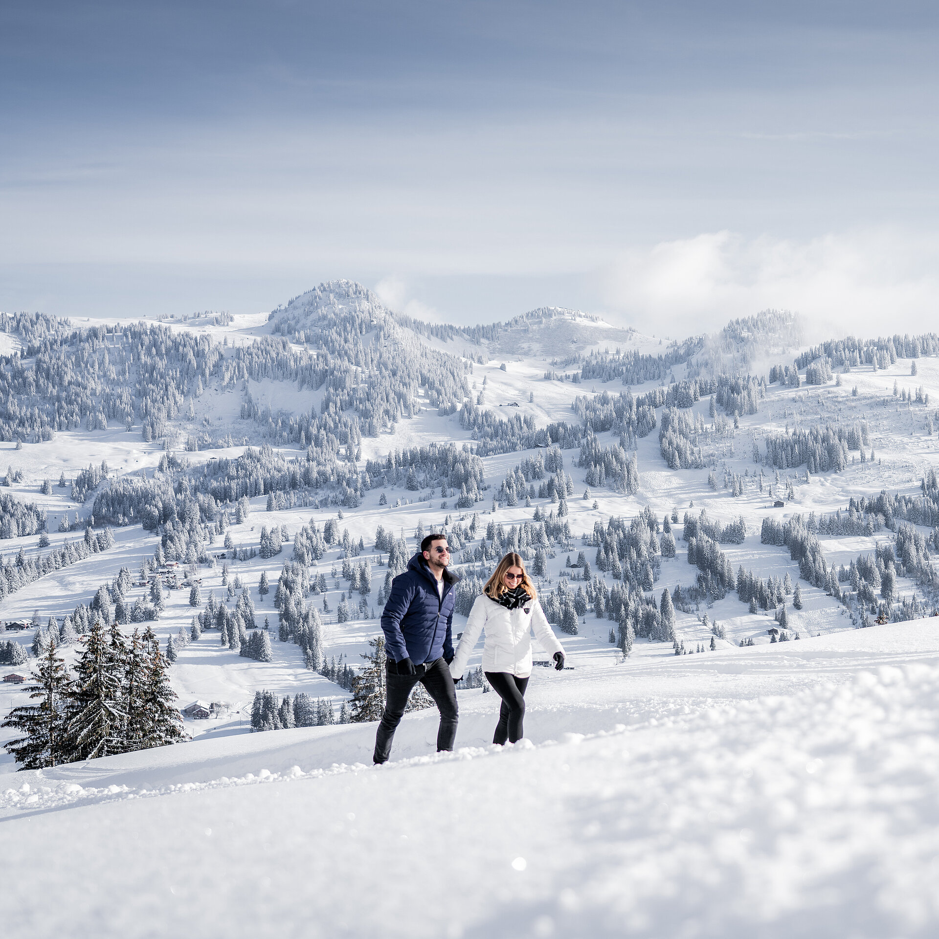 <p>Zwei Personen wandern im Schnee vor einer imposanten Bergkulisse</p>