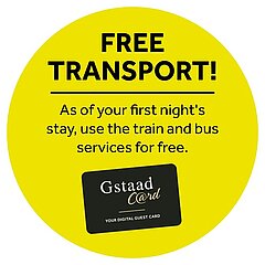 Gelber Punkt mit schwarzem Text&nbsp;«Free transport! - As of your first night's stay, use the train and bus services for free» sowie schwarz-weiss-goldiges Gstaad Card Logo.