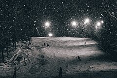 Beleuchtete Skipiste in der Nacht.