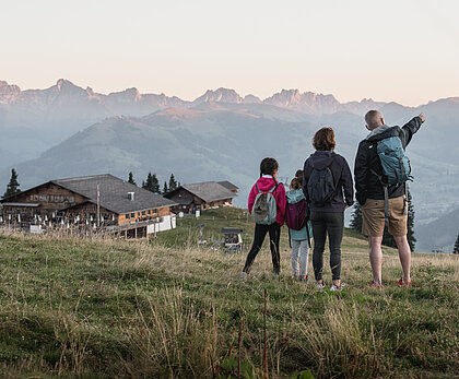 Wandern Sparenmoos Familie mit zwei Kindern geniessen die Aussicht von der Wispile. Dahinter befindet sich die Wispile Bergstation.