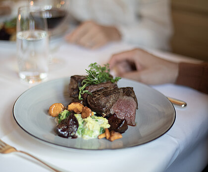 Ein schön angerichtetes Teller mit einem saftigen Fleisch und Beilage.