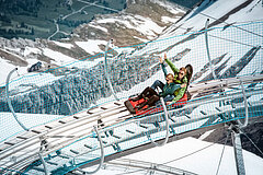 Zwei Personen die Spass haben auf dem Alpine Coaster auf dem Glacier3000.