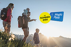 Eine Frau, ein Mann und zwei Kinder auf einer grünen Wiese. Im Hintergrund Berge und ein Sonnenuntergang. Blau-weisses Magic Pass Logo und gelber Button "ab Sommer 2025".