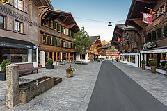 Strasse führt zwischen hölzernen Chalets hindurch.