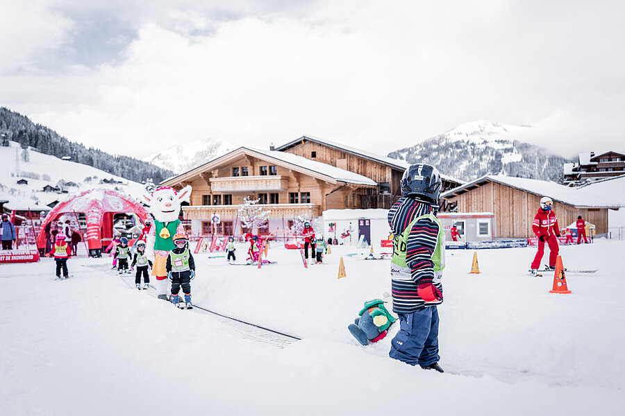 Busy Saani's Snowliand with lots of kids on skis, ski instructors and Saani on the ski slope in the valley.