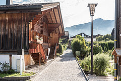 Ein kleiner Weg führt an Holz Chalets und grünen Gärten vorbei.