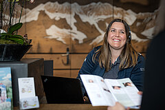 Mitarbeiterin Gstaad Saanenland Tourismus beratet Kunden.