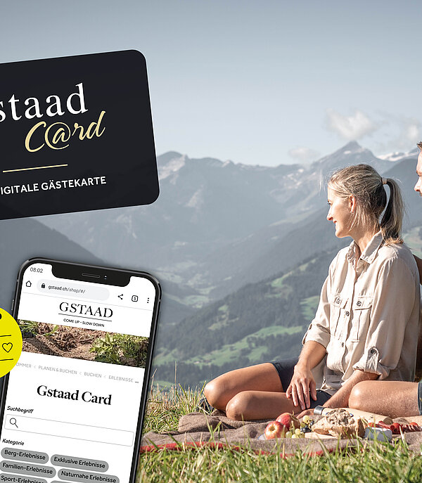 On the right, a man and a woman sitting on a picnic blanket on a mountain and enjoying the view; on the left, an advertising banner for the Gstaad Card.