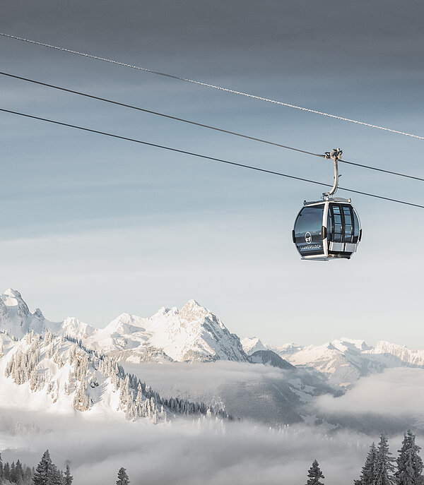 Gondelbahn Saanersloch Fokus ist auf der Saanersloch Gondelbahn mit verschneitem Bergpanorama im Hintergrund