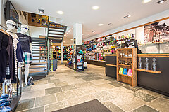 A sports store with a cash register and lots of sporting goods for sale.