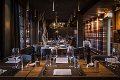 Nobles Restaurant mit gedeckten Tischen und verschiedenen Dekorationen.