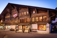 Das Museum ist ein altes Saanenhaus. Das Parterre ist weiss gemauert, die beiden nächsten Stockwerke sind mit altem Holz gebaut. Die Fenster sind klein und haben "Putzerscheiben". Drinnen brennen bereits die Lichter, draussen ist die Dämmerung da.