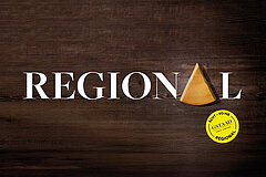 Piece of regional cheese on a dark wooden background with the word “REGIONAL” and the label “Ächt vo hie – Gstaad”.