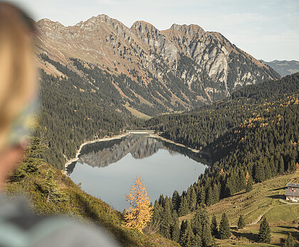 A woman enjoying a clear view over Arnensee in autumn.