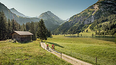 Zwei Mountainbiker fahren beim malerischen Lauenensee vorbei