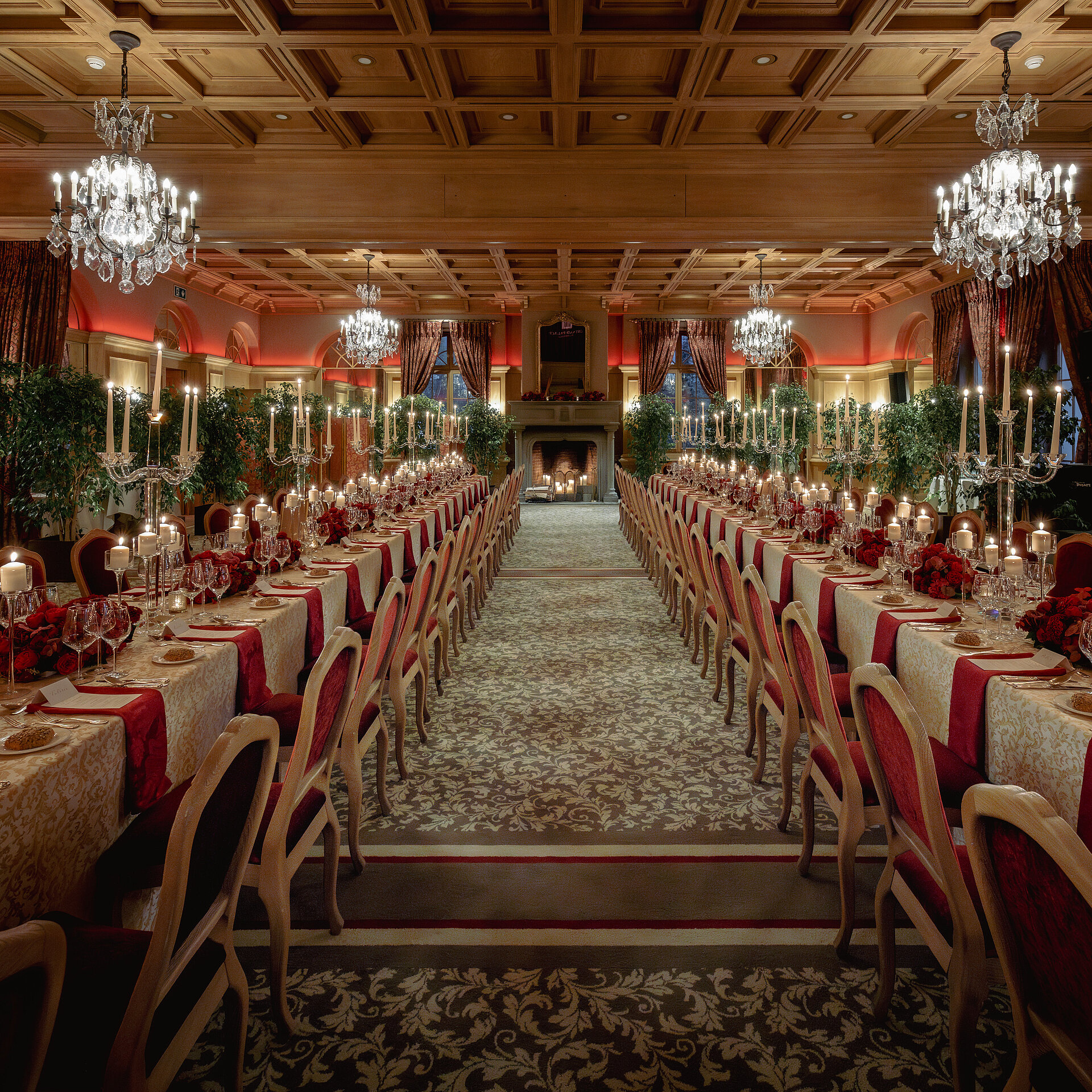 <p>In einem luxuriösen Saal steht ein langer Tisch mit Kerzen, Weingläsern und Blumen.</p>