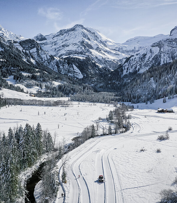<p>Drohnenaufnahme vom verschneiten Lauenen Tal im Winter. Im Hintergrund die verschneiten Berge.</p>